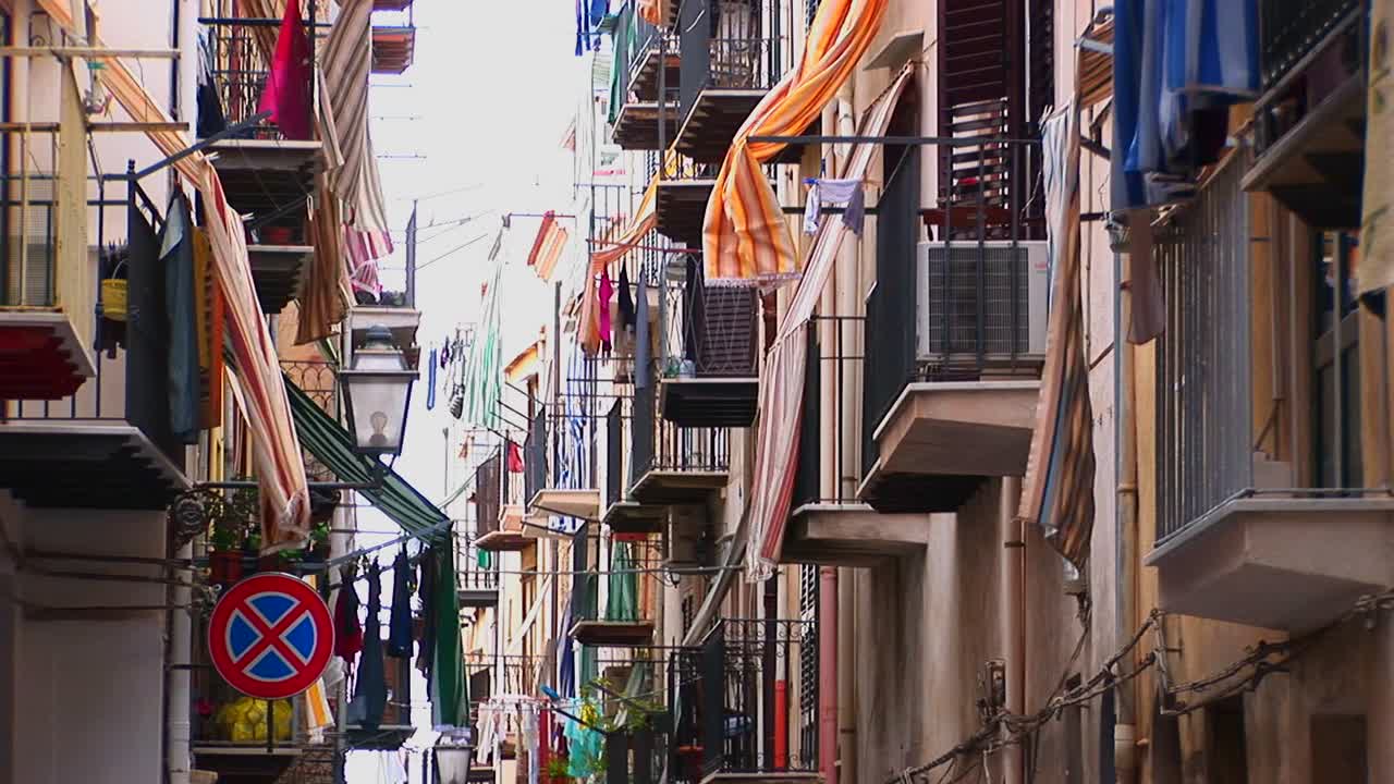 체팔루 이탈리아의 발코니와 계단에서 옷을 말리는 밀접하게 배치된 집들 사이의 골목