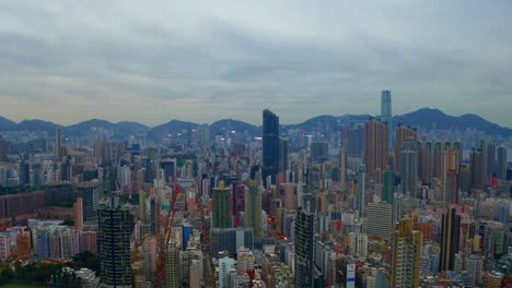 Drone-shot-,traveling-to-the-right,-of-a-big-city-during-a-cloudy-day-with-business-buildings-in-the-distance-1