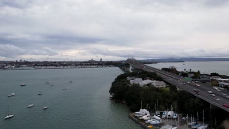 Luftaufnahme-Der-Auckland-Harbour-Bridge-In-Auckland,-Neuseeland-Mit-Autoverkehr-Und-Booten-4k