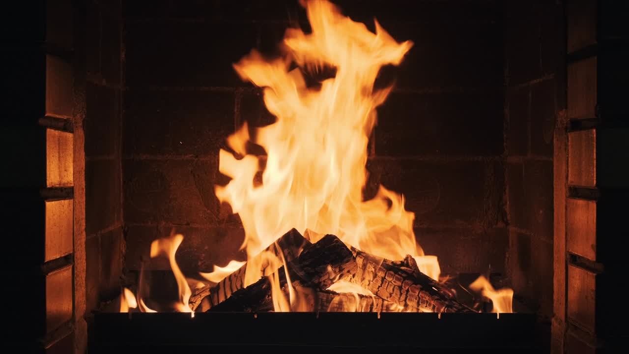 Fire in the fireplace in lobby of large resort hotel in mountains slow motion. Dry burning firewood in fireplace. Pattern of bright orange flame. Relax. Family holidays