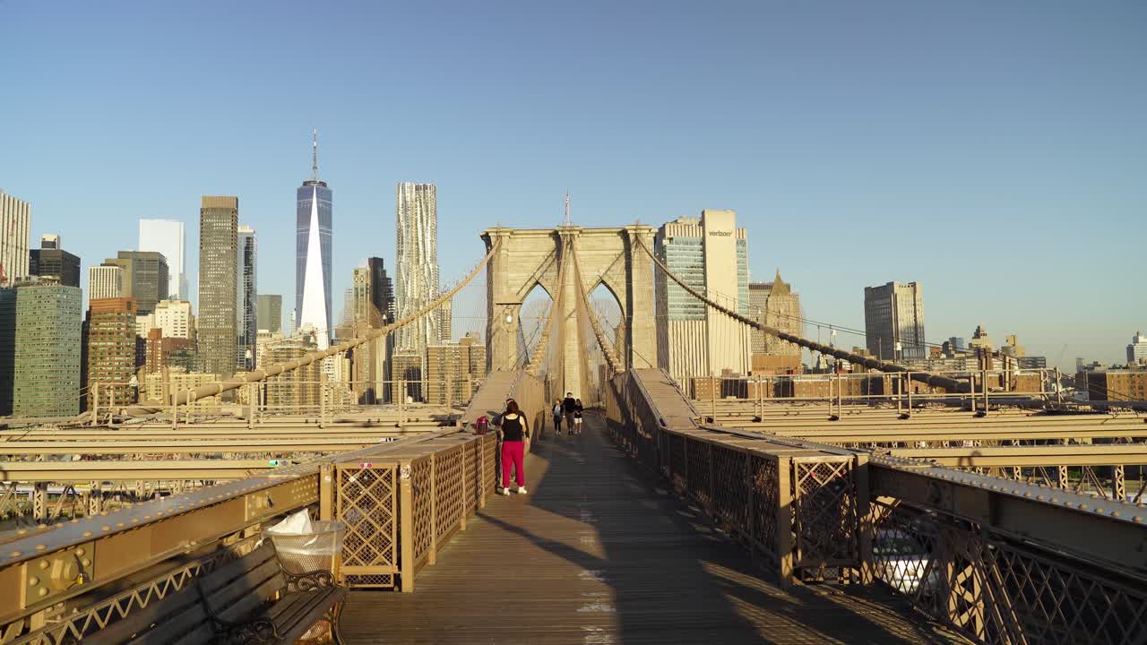 Commuters Crossing Brooklyn Bridge in New York on a Sunny Evening