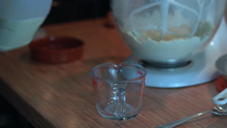 pouring milk into measuring cup for baking