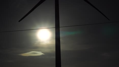 Propeller-Of-A-Wind-Turbine-In-Silhouette-Spinning-Against-Bright-Sun-In-Son-Hai,-Ninh-Thuan,-Vietnam