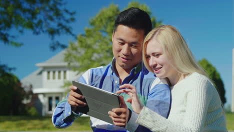 Happy-Couple-Using-Tablet-Outdoors