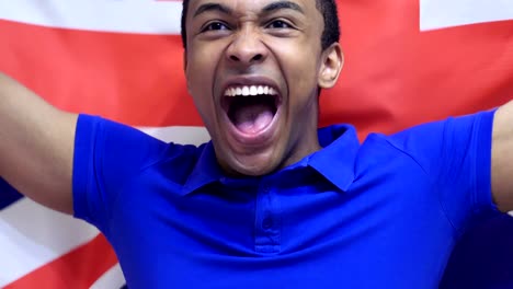 un fanático británico celebra sosteniendo la bandera británica en cámara lenta