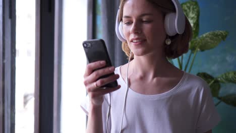 smiling girl listening and choosing song at telephone