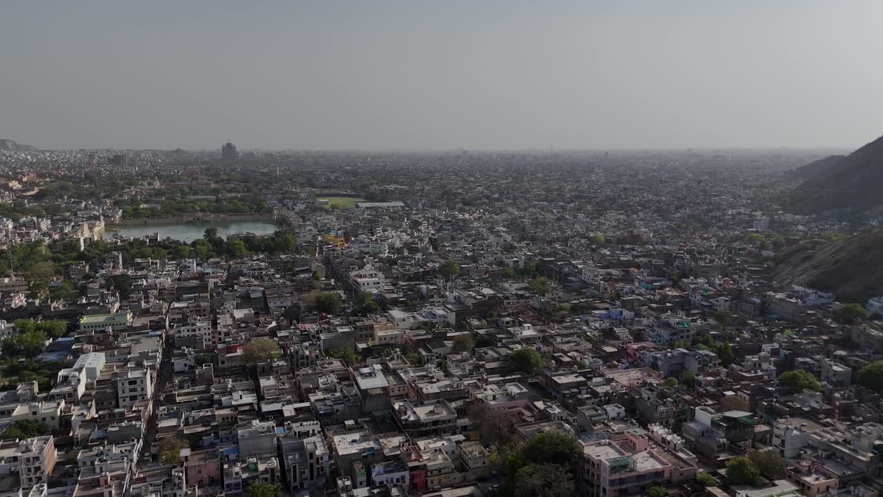 High-angle drone shot of metro infrastructure cutting through Jaipur cityscape.