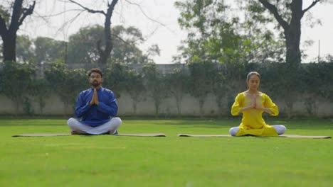 indian couple doing namaste yoga pose