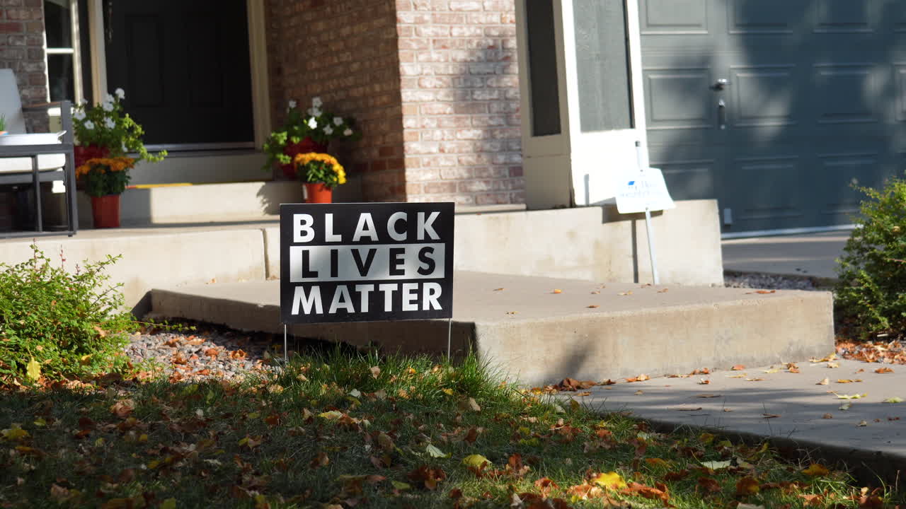 Black Lives Matter Yard Sign on Front Porch of House Steps with Flowers