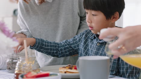 Familia-Asiática-Feliz-Comiendo-Panqueques-Para-El-Desayuno,-Niños-Disfrutando-De-Una-Comida-Casera-Saludable-Con-Sus-Padres-El-Fin-De-Semana-Por-La-Mañana-En-La-Cocina,-Imágenes-De-4k