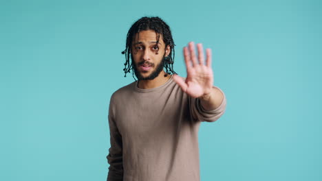 annoyed person doing firm stop sign gesturing, studio background