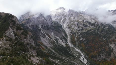 mystic mountain landscape with high peaks covered in fog and clouds in autumn, albanian alps