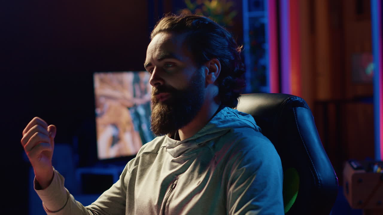 hombre jugando videojuegos en vivo mientras charla con la audiencia en línea desde la sala de estar iluminada por rgb