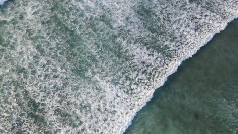 Vista-Superior-Aérea-De-4k-De-Espuma-De-Olas-En-Un-Hermoso-Fondo-De-Textura-De-Mar-Turquesa