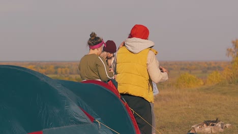 guy-in-orange-warm-vest-gets-out-of-tent-ladies-look-at-man