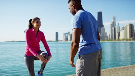 multi ethnic people training outdoors by city shoreline