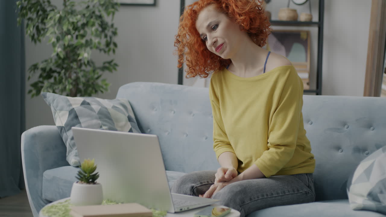 mujer usando una computadora portátil en un sofá