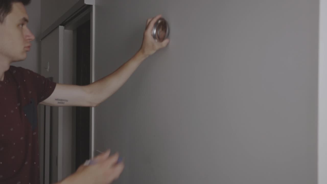 hombre marcando la pared con un lápiz