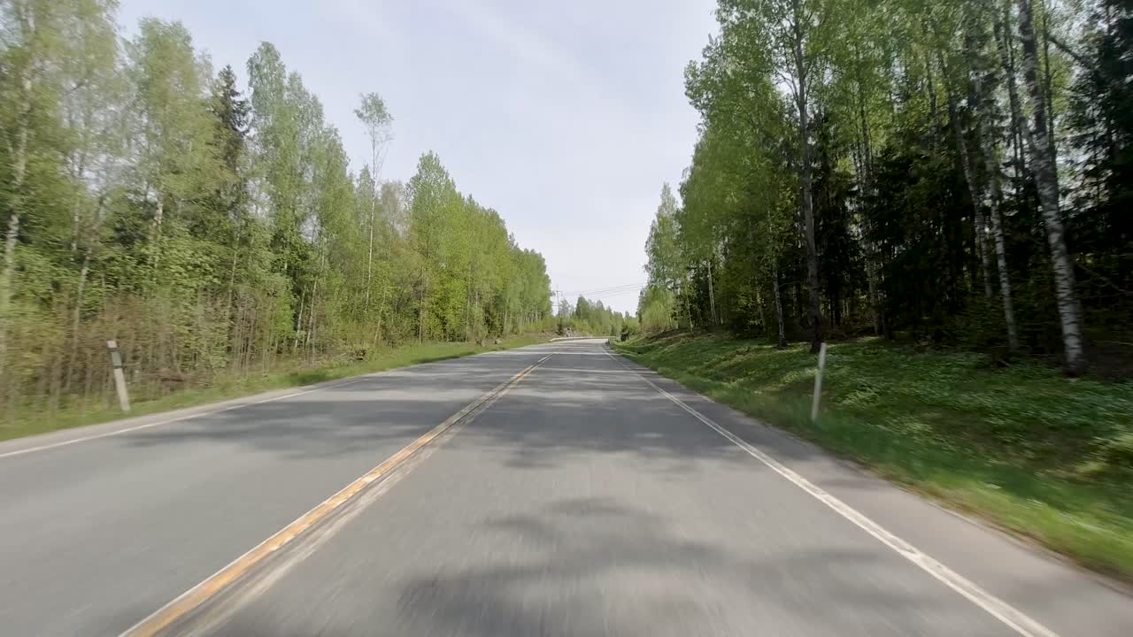 자동차가 숲 속의 도로를 가로질러 이동할 때, 다른 차량들과 길을 공유하며, 이 경치와 자연이 풍부한 환경에서 움직임과 활동의 느낌을 만 ⁇ 니다.