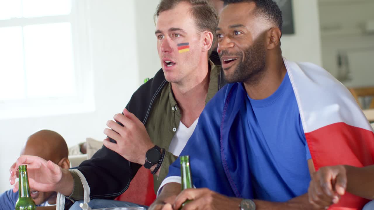 Video verticale: Reazione a un gol, amici sul divano con bandiere e pittura facciale che esultano, prendendo birra.