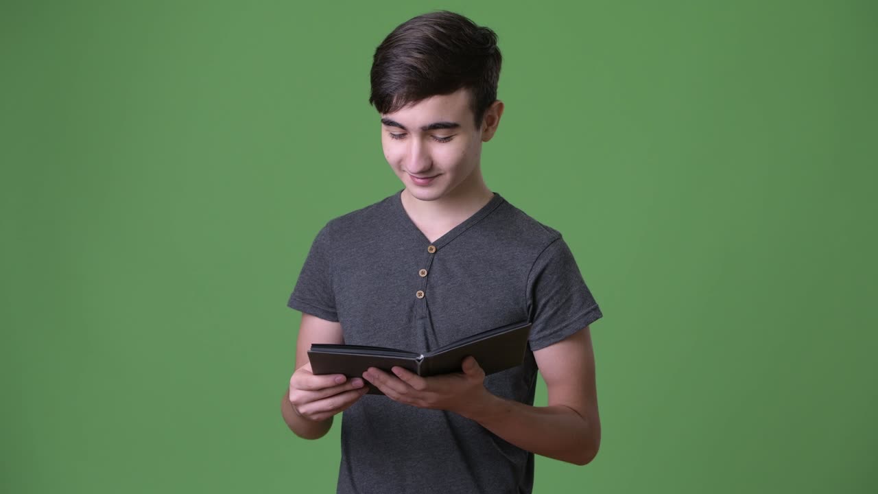 초록색 배경에 젊은 잘생긴 이란 십대 소년