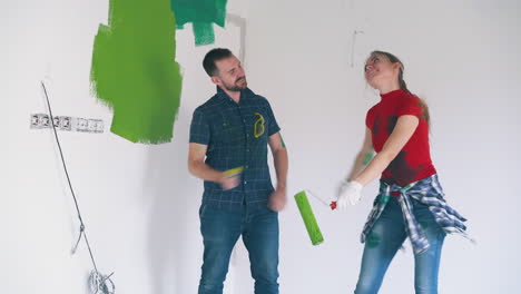 Familia-De-Chico-Y-Chica-Baila-Con-Herramientas-De-Pintura-En-La-Habitación