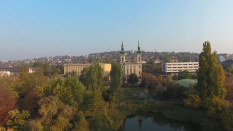 aerial shot of a church in a park with lake