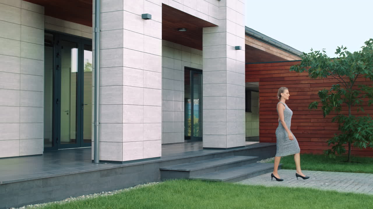 una mujer elegante sale de una casa rica, una mujer de negocios sale de un hotel.