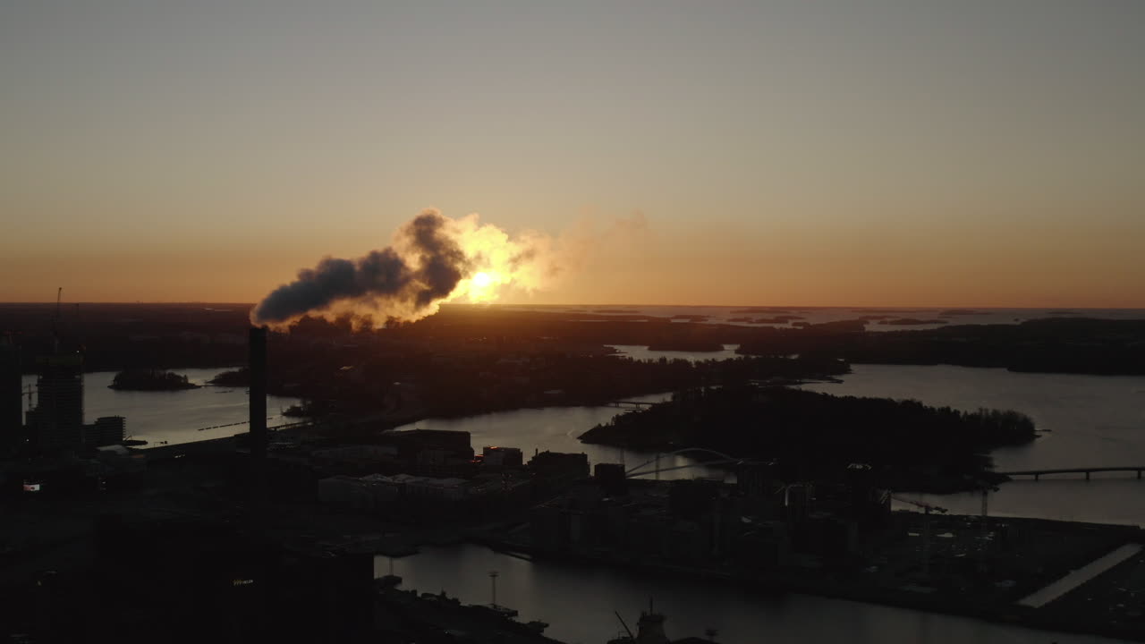 Sun light behind smoke exhaust from industrial chimney. Air Pollution. Sunset