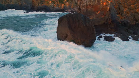 splashing waves crashing rocks closeup. ocean surf making white foam coastline