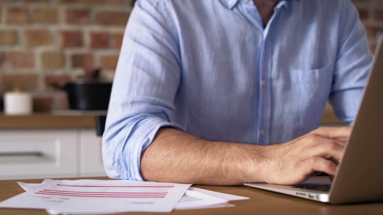 video de cerca de un hombre trabajando en una computadora portátil en casa