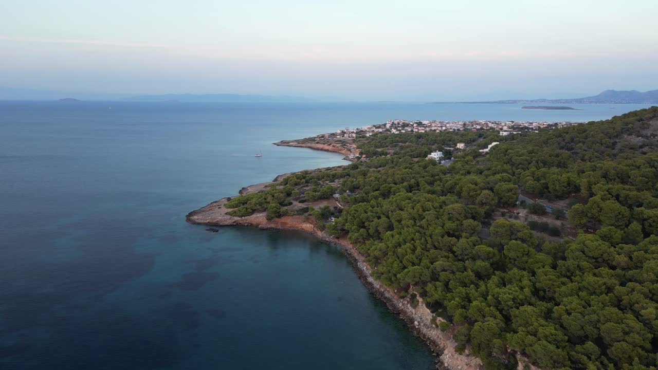 Stunning forward drone flight over Greek island with sailing boat and village