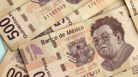 close-up of many mexican 500 peso bills being thrown on table