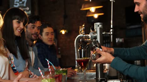 bartender serving cocktail at bar counter