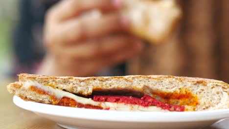 mujer comiendo un sándwich tostado