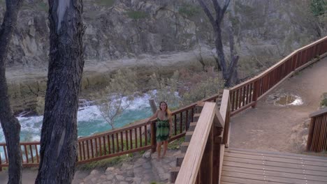 woman stand at north gorge walk with ocean views in background - tourist attraction in point lookout, australia