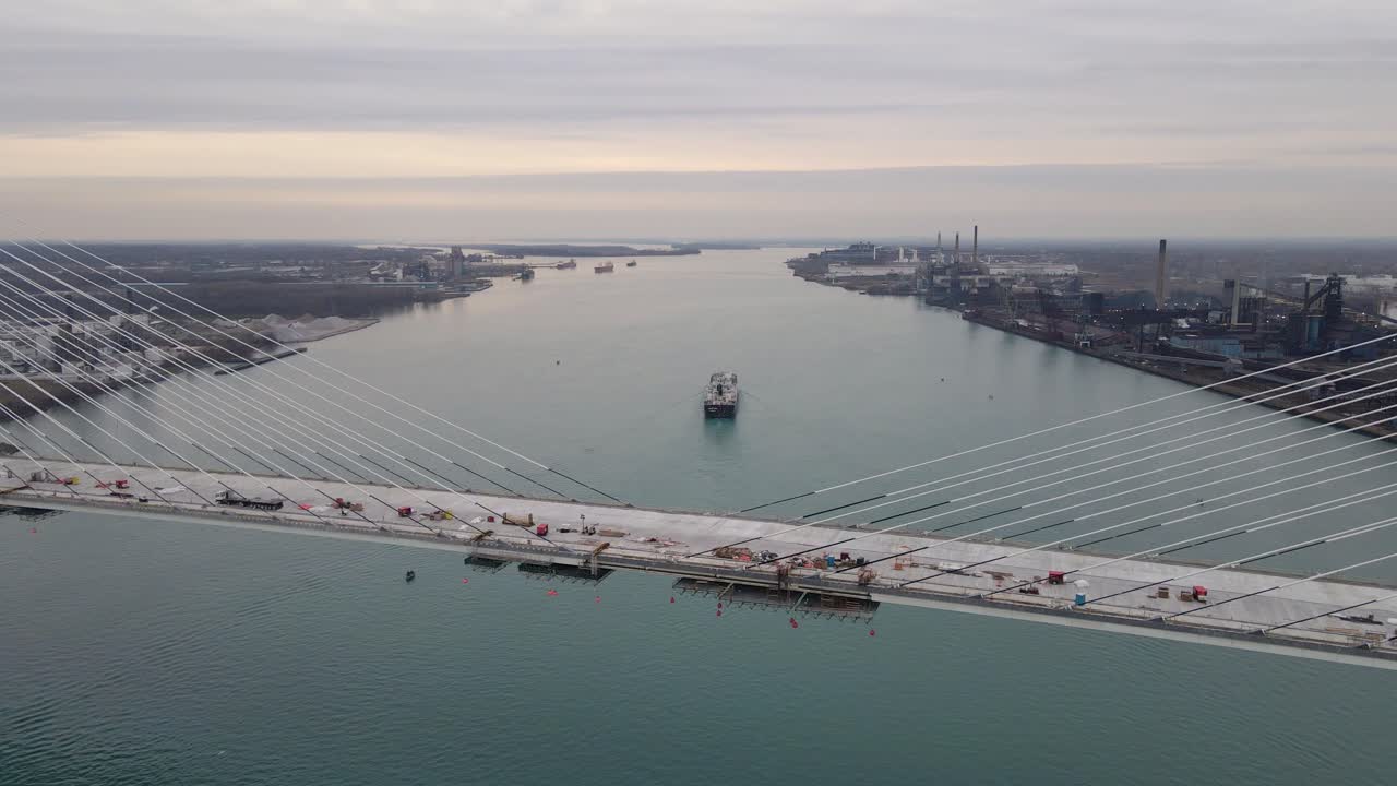 Cargo ship on Detroit River with Gordie Howe Bridge in aerial view