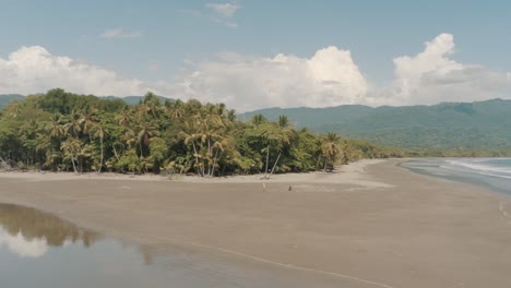 Drone-Aéreo-Volando-Bajo-En-Una-Hermosa-Playa-Con-Palmeras-En-Costa-Rica