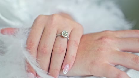 a close up shot in the morning light of the brides hand wearing an engagement ring thats big and sparkly