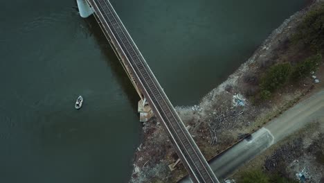 fishermen on a raft float down a river and pass under a bridge