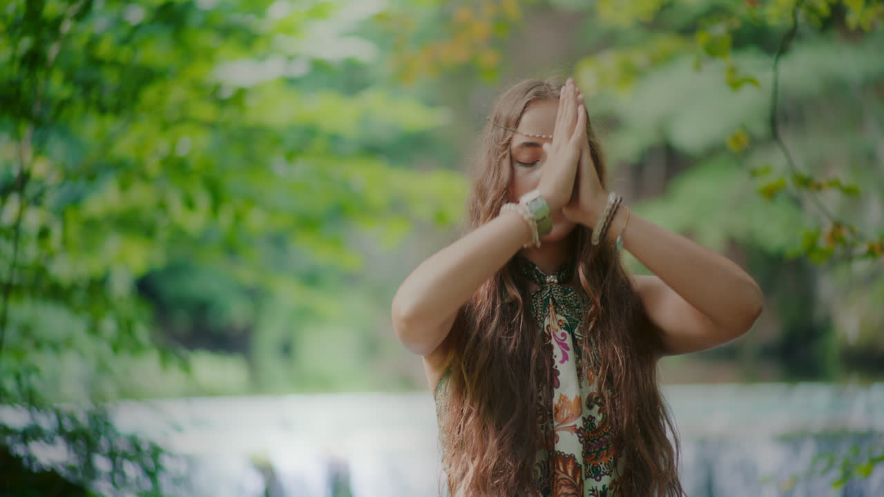 숲 속 의 폭포 앞 에서 명상 하는 여자