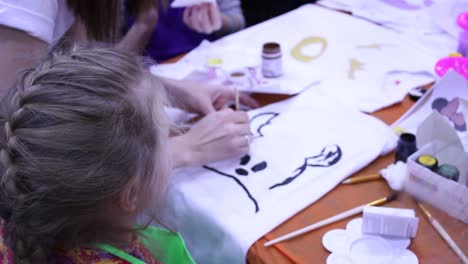 kids painting t-shirts in an art class