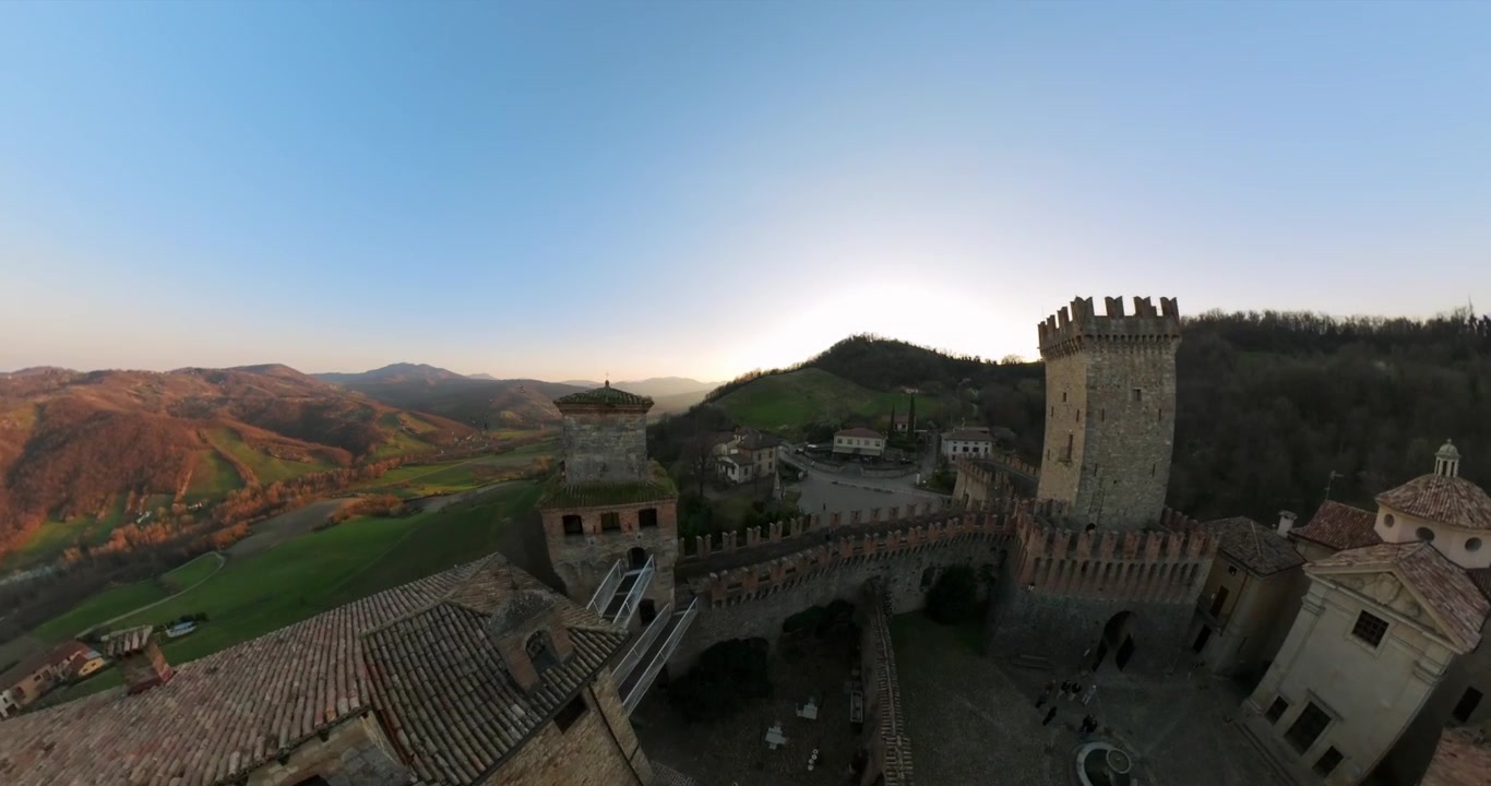 La telecamera esegue un'orbita a 360 gradi attorno al borgo di Rocca Viscontea di Castell’Arquato al tramonto