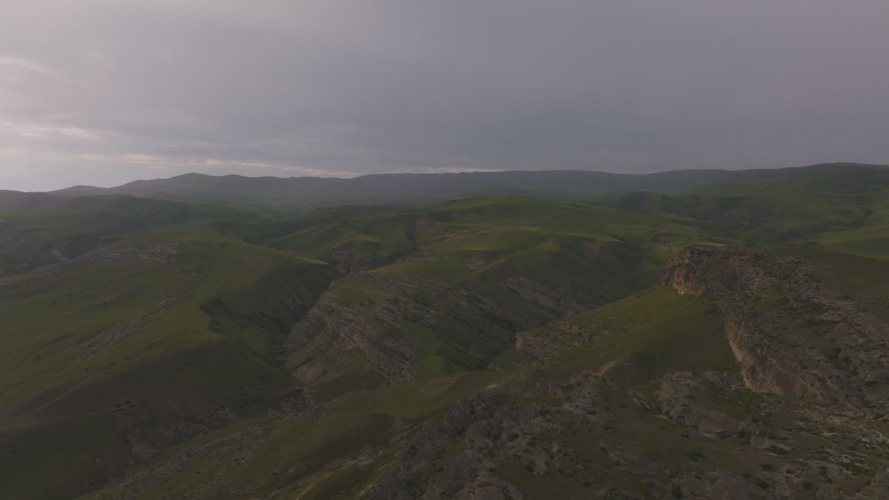 vista de pájaro sobre la cordillera rocosa verde brumosa al atardecer amanecer