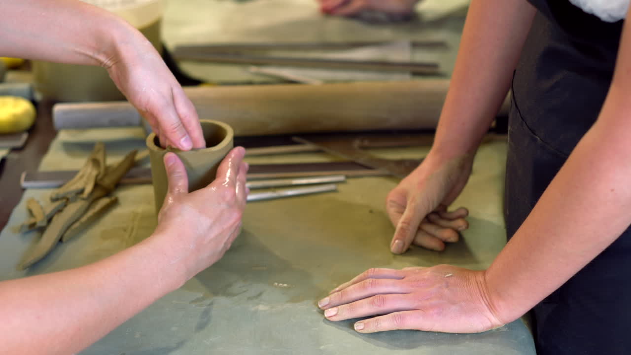 Students modelling clay into cups