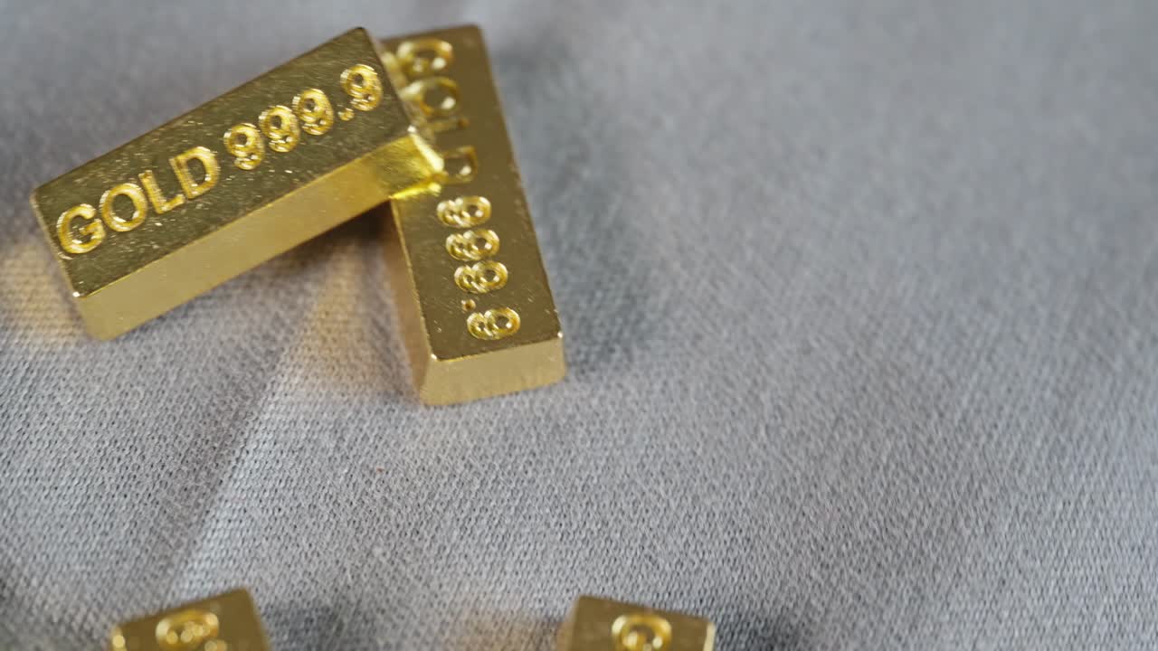 999로 표시된 금동이 회색 표면에 빠르게 회전하여 부와 가치를 상징합니다.