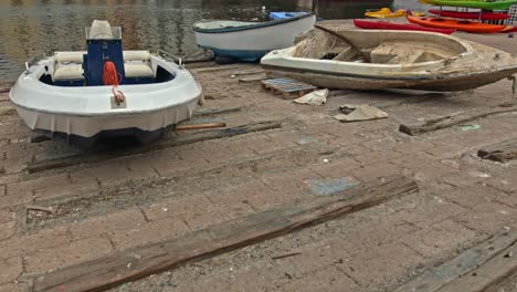 rising reveal of boats moored on the riverside with a bridge and city background