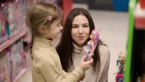 Shopping-concept.-Mother-and-daughter-are-buying-dolls-in-the-mall,-slow-motion