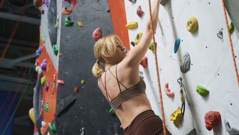 mujer en un centro de pared de escalada
