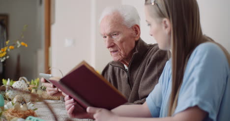 young woman surfing internet with grandfather on digital tablet